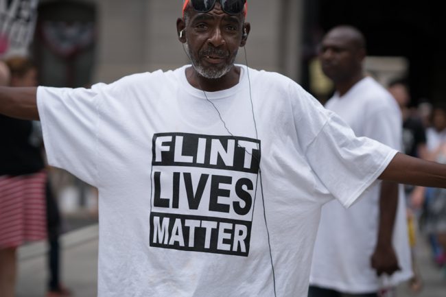 Man with shirt that reads "Flint Lives Matter"