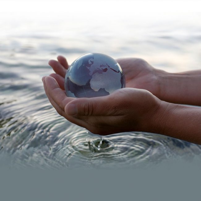 hand with water globe over water