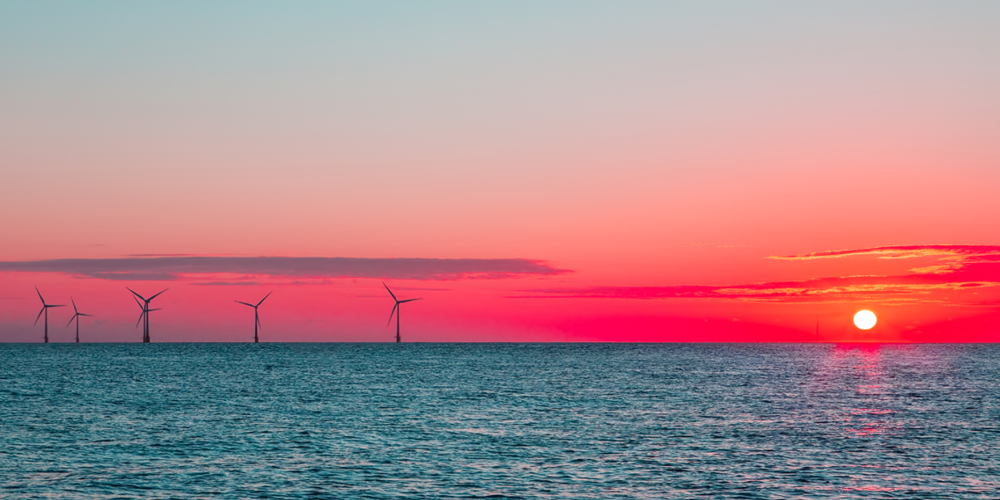 Ocean with Wind Turbines and Sun Setting